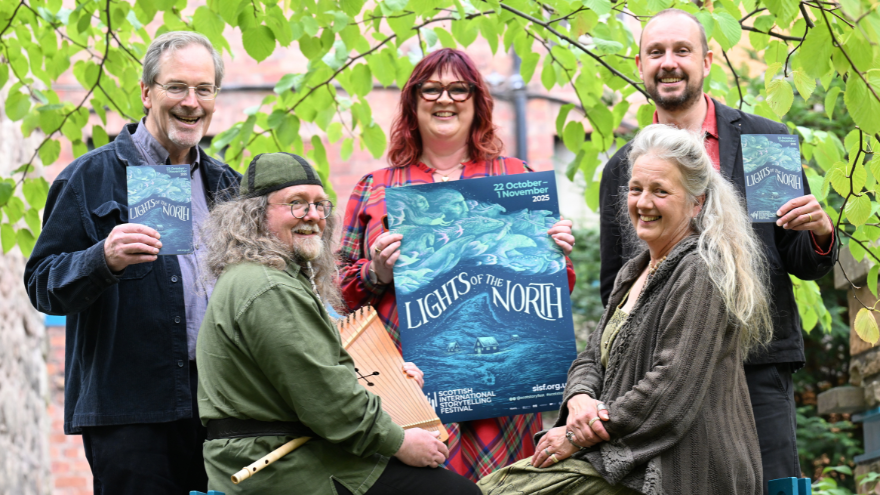 5 people holiding up the festival programme at the launch of the Scottish International Storytelling Festival